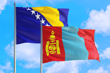 Mongolia and Bosnia Herzegovina national flag waving in the windy deep blue sky. Diplomacy and...