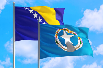 Northern Mariana Islands and Bosnia Herzegovina national flag waving in the windy deep blue sky....