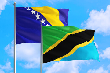 Tanzania and Bosnia Herzegovina national flag waving in the windy deep blue sky. Diplomacy and international relations concept.