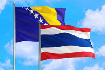 Thailand and Bosnia Herzegovina national flag waving in the windy deep blue sky. Diplomacy and international relations concept.