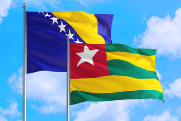 Togo and Bosnia Herzegovina national flag waving in the windy deep blue sky. Diplomacy and international relations concept.