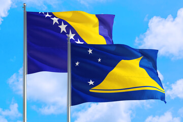 Tokelau and Bosnia Herzegovina national flag waving in the windy deep blue sky. Diplomacy and international relations concept.