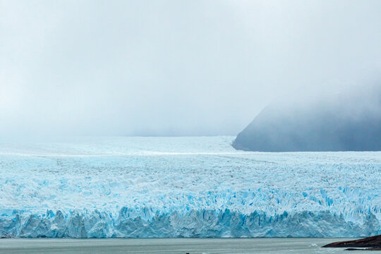glaciar perito moreno com o oceano a frente toda sua imensid&atilde;o com suas paredes de gelo , e mantenhas e muita neblina ao fundo 