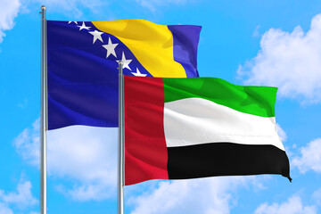 United Arab Emirates and Bosnia Herzegovina national flag waving in the windy deep blue sky. Diplomacy and international relations concept.