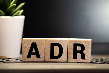 Letter block in word ADR Abbreviation of adverse drug reaction on wood background