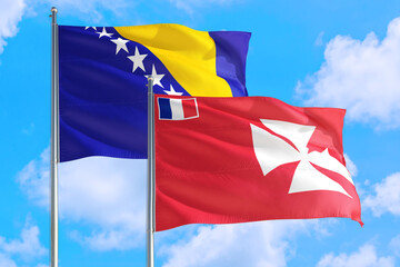 Wallis And Futuna and Bosnia Herzegovina national flag waving in the windy deep blue sky. Diplomacy and international relations concept.