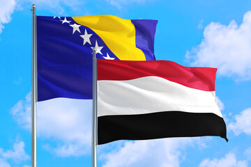 Yemen and Bosnia Herzegovina national flag waving in the windy deep blue sky. Diplomacy and international relations concept.