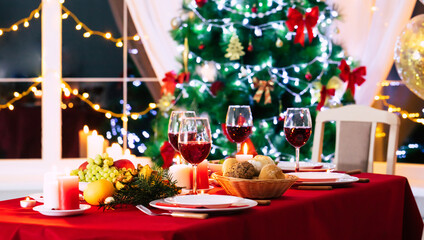 Bright decorated big new year dinner table with christmas tree on background