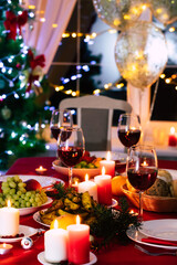 Bright decorated big new year dinner table with christmas tree on background