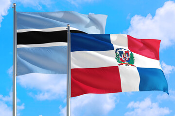 Fototapeta na wymiar Dominican Republic and Botswana national flag waving in the windy deep blue sky. Diplomacy and international relations concept.