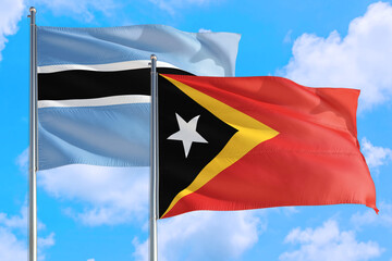 East Timor and Botswana national flag waving in the windy deep blue sky. Diplomacy and international relations concept.