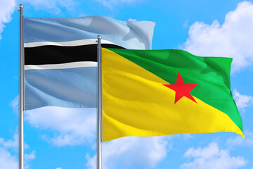 French Guiana and Botswana national flag waving in the windy deep blue sky. Diplomacy and international relations concept.