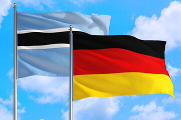 Germany and Botswana national flag waving in the windy deep blue sky. Diplomacy and international relations concept.