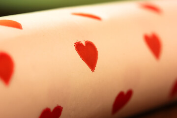 Festive background on Valentine's Day or Valentine's Day, red little hearts on white background. Gift paper close-up
