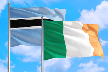 Ireland and Botswana national flag waving in the windy deep blue sky. Diplomacy and international relations concept.