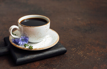 Cup with chicory drink on a wooden tray on a brown background. Alternative to coffee. Healthy beverage. Space for text.