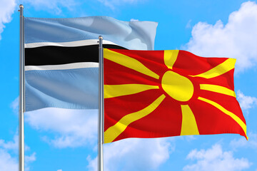 Macedonia and Botswana national flag waving in the windy deep blue sky. Diplomacy and international relations concept.