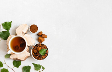 Obraz na płótnie Canvas Chaga tea on a white background. Traditional Russian drink with pieces of birch mushroom. Copy space, top view, flat lay.