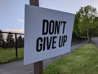 Fototapeta premium a Don't Give Up motivational sign in a yard during the COVID-19 pandemic