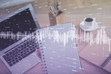 Double exposure of businesswoman hands typing on computer and forex chart hologram drawing. Financial analysis concept.