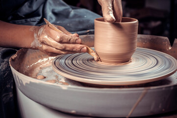 Pottery woman demonstrates the process of making ceramic dishes using the old technology. Handmade. Close-up.