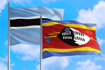 Swaziland and Botswana national flag waving in the windy deep blue sky. Diplomacy and international relations concept.