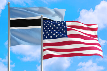 United States and Botswana national flag waving in the windy deep blue sky. Diplomacy and international relations concept.