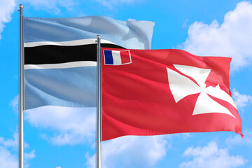 Wallis And Futuna and Botswana national flag waving in the windy deep blue sky. Diplomacy and international relations concept.