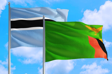 Zambia and Botswana national flag waving in the windy deep blue sky. Diplomacy and international relations concept.