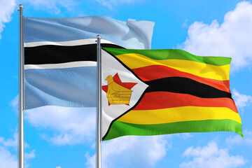 Zimbabwe and Botswana national flag waving in the windy deep blue sky. Diplomacy and international relations concept.