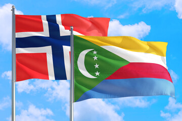Comoros and Bouvet Islands national flag waving in the windy deep blue sky. Diplomacy and international relations concept.