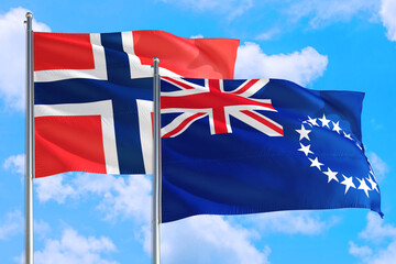 Cook Islands and Bouvet Islands national flag waving in the windy deep blue sky. Diplomacy and international relations concept.