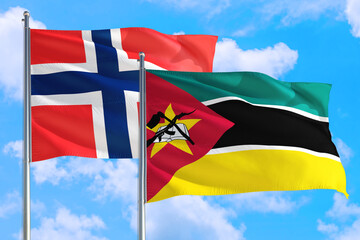 Mozambique and Bouvet Islands national flag waving in the windy deep blue sky. Diplomacy and international relations concept.