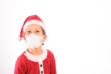 A child like Santa Claus, isolated on white background, wears a mask on his face to protect himself from viruses at Christmas.