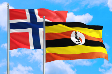 Uganda and Bouvet Islands national flag waving in the windy deep blue sky. Diplomacy and international relations concept.