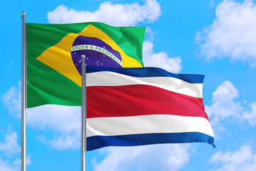 Cote D'Ivoire and Brazil national flag waving in the windy deep blue sky. Diplomacy and international relations concept.