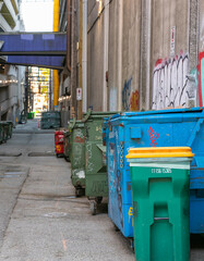 garbage wheelie bins for recycling household waste lined up on the street of Vancouver city BC. Street view, travel photo, selective focus.