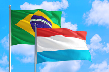 Macao and Brazil national flag waving in the windy deep blue sky. Diplomacy and international relations concept.