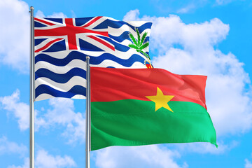 Burkina Faso and British Indian Ocean Territory national flag waving in blue sky. Diplomacy and...