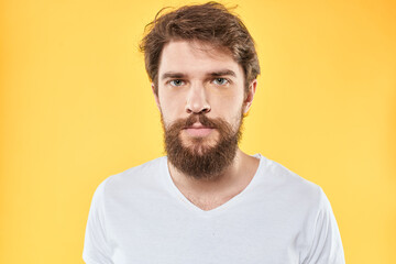 Fototapeta premium emotional bearded man in t-shirt cropped view yellow background studio