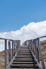 Obraz premium A vertical shot of a staircase leading to the mountains touching the sky in Galapagos Islands, Ecuador