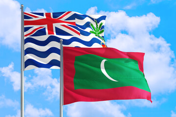 Maldives and British Indian Ocean Territory national flag waving in blue sky. Diplomacy and international relations concept.