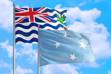Micronesia and British Indian Ocean Territory national flag waving in blue sky. Diplomacy and international relations concept.