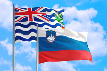 Slovenia and British Indian Ocean Territory national flag waving in blue sky. Diplomacy and international relations concept.