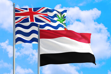 Yemen and British Indian Ocean Territory national flag waving in blue sky. Diplomacy and international relations concept.