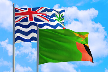 Zambia and British Indian Ocean Territory national flag waving in blue sky. Diplomacy and international relations concept.