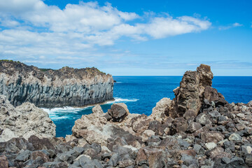 Stacked cliff volcanic rocks next to the turquoise sea in Alagoa da Fajãzinha, Terceira - Azores PORTUGAL