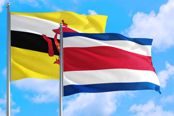 Costa Rica and Brunei national flag waving in the windy deep blue sky. Diplomacy and international relations concept.