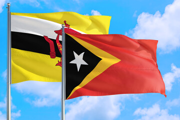 East Timor and Brunei national flag waving in the windy deep blue sky. Diplomacy and international relations concept.