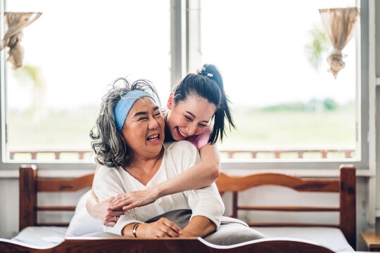 Portrait of enjoy happy love asian family senior mature mother and young daughter smiling laughing embracing and having fun together in moments good time at home